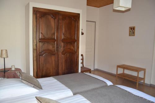 a bedroom with a bed with a wooden door at Le Tilleul de Ray in Ray-sur-Saône