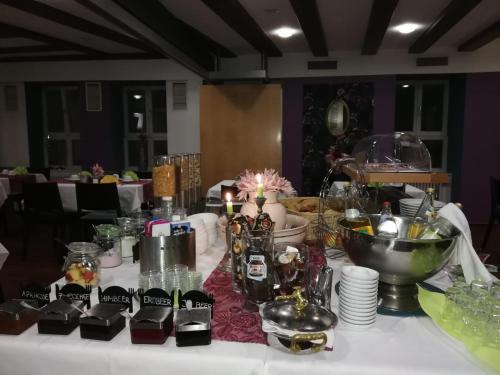 a table with a white table cloth with dishes and drinks at Hotel Restaurant Rössle in Calw