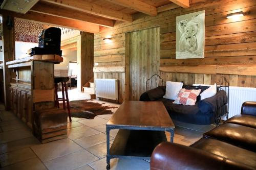 a living room with a couch and a table in a cabin at La Ferme du Douanier & Spa 5 étoiles ALL INCLUSIVE in Ventron