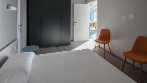 a bedroom with a white bed and two chairs at Italianway - Villa Paloma in Marone