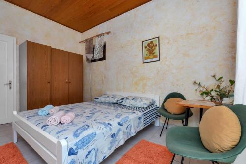 1 dormitorio con 1 cama, mesa y sillas en Apartments Vele, en Makarska