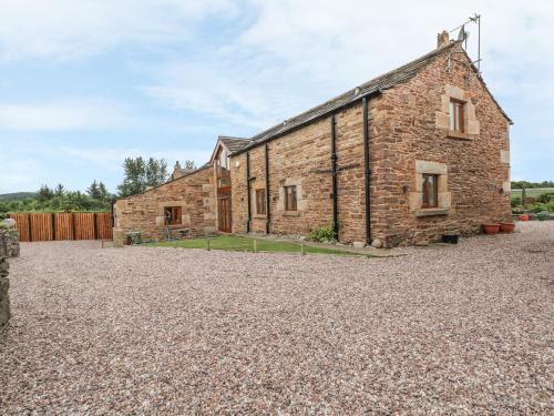 an old stone house on a gravel driveway at Rose Hips Barn in Chorley