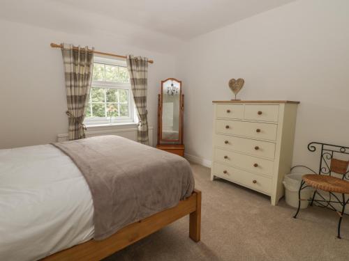 Un pat sau paturi într-o cameră la Humble Bee Cottage