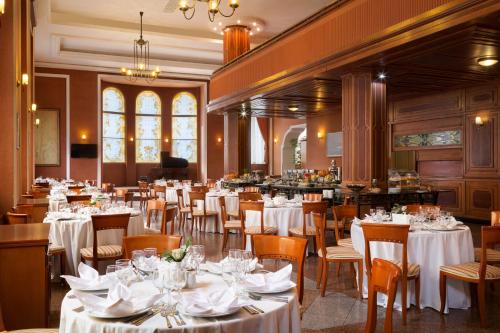a dining room with white tables and chairs at Ramada by Wyndham Plovdiv Trimontium in Plovdiv