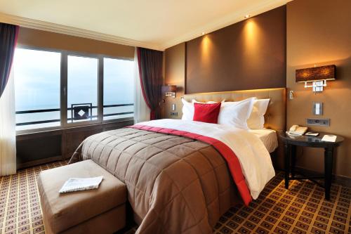 a hotel room with a large bed and a window at Grand Hotel Huis ter Duin in Noordwijk aan Zee