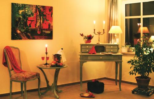 Habitación con mesa, silla y mesa con velas en Hammers Landhotel GmbH, en Teltow