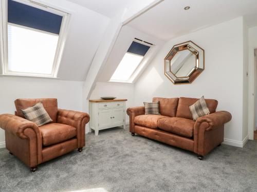 a living room with two chairs and a mirror at 2 Rodgers Mews in Malton