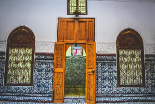 una porta aperta in una stanza con due finestre di Riad Tetuanía a Tétouan