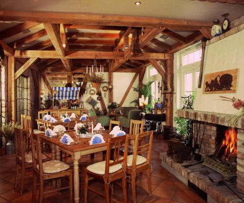 uma sala de jantar com uma mesa e uma lareira em Hammers Landhotel GmbH em Teltow