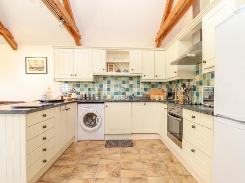 a kitchen with white cabinets and a dishwasher at Valley View in Helston