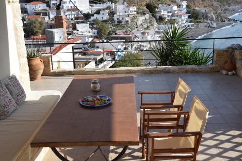a wooden table and chairs on a balcony with a view at Aeriko House in Paránimfoi
