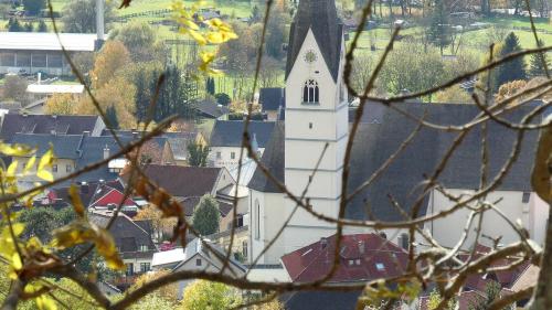 a large white church with a steeple in a town at Haus Pleterski in Obervellach
