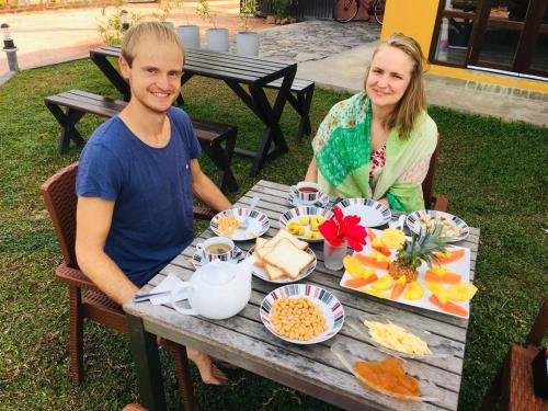 a man and a woman sitting at a table with food at Canal's Edge in Negombo