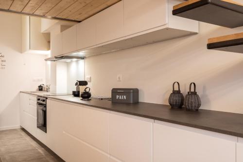 une cuisine avec des armoires blanches et un comptoir dans l'établissement DIFY D'Aguesseau - Quai du Rhône, à Lyon