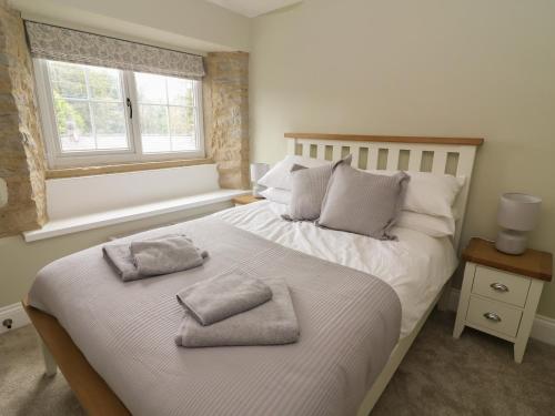 a bedroom with a large bed with two pillows on it at 5 Bank Cottage in Lancaster