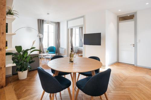 un salon avec une table et des chaises en bois dans l'établissement DIFY Cosy - Centre Ville, à Lyon
