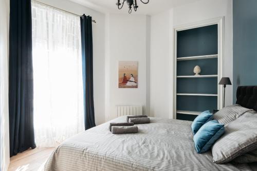 une chambre avec un grand lit avec des oreillers bleus dessus dans l'établissement DIFY Joli - Place des Brotteaux, à Lyon