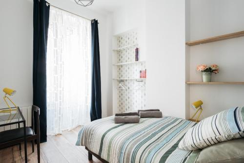 um quarto com uma cama e uma janela em DIFY Joli - Place des Brotteaux em Lyon