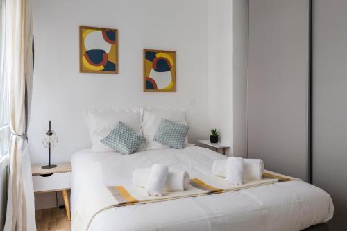 una camera con un letto bianco con due cuscini di DIFY Bonheur - Brotteaux a Lione