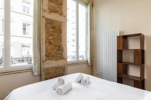 a bedroom with a white bed with towels on it at DIFY Lumière - Masséna in Lyon