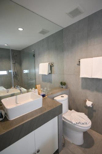 a bathroom with a sink and a toilet at Benviar Tonson Residence in Bangkok