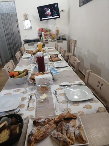 a long table with plates of food on it at Opera Boutique Rooms in Monreale