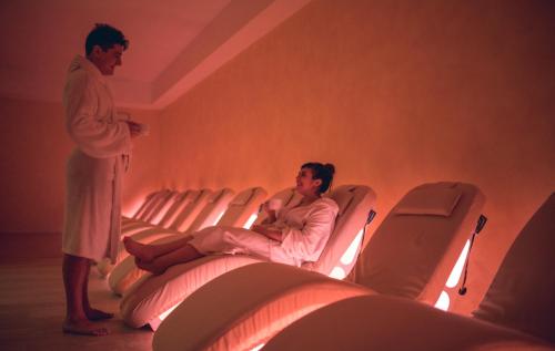 a man standing next to a woman in a waiting room at Casanova - Wellness Center La Grotta Etrusca in San Quirico dʼOrcia