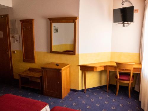 a hotel room with a desk and a mirror at Hotel Ristorante Centrale in Rovere Veronese