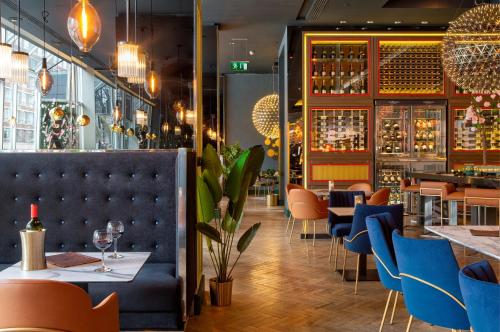 a restaurant with blue chairs and a bar at Pullman London St Pancras in London