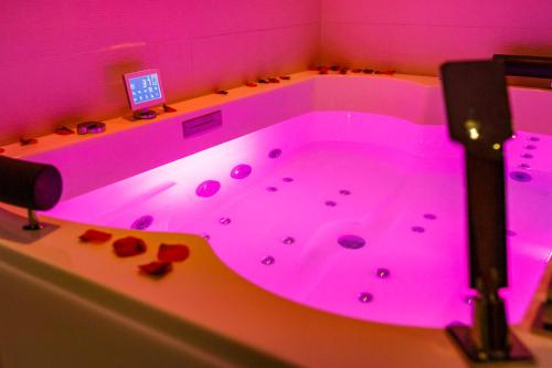 a bathroom with a pink tub with a laptop on it at Best Western Les Bains Hotel et SPA in Perros-Guirec