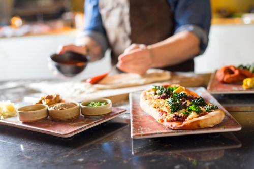 a person preparing food on a counter with plates of food at Pullman London St Pancras in London