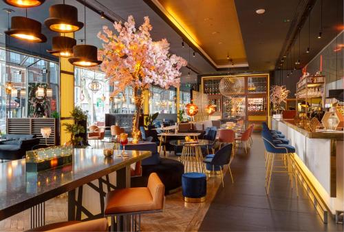 a restaurant with tables and chairs and a bar at Pullman London St Pancras in London