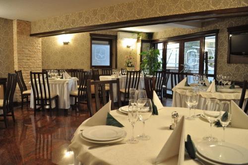 un restaurante con mesas y sillas con manteles blancos en Acapulco Hotel, en Ploieşti