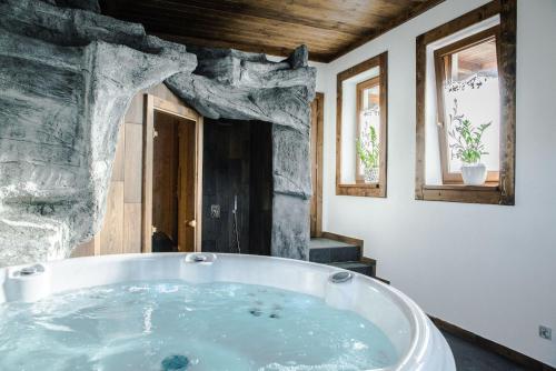 a large bath tub in a room with windows at Sielanka Apartamenty SPA in Białka Tatrzanska