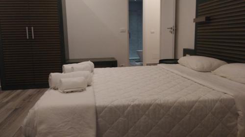 um quarto com uma grande cama branca e 2 cadeiras em Suite White em Turim