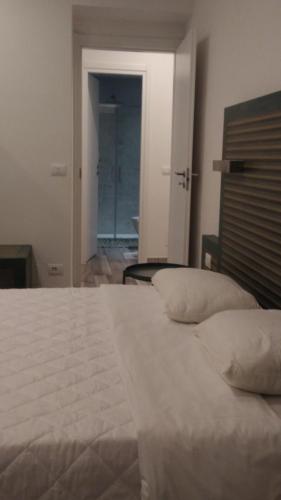 um quarto com uma grande cama branca com almofadas em Suite White em Turim