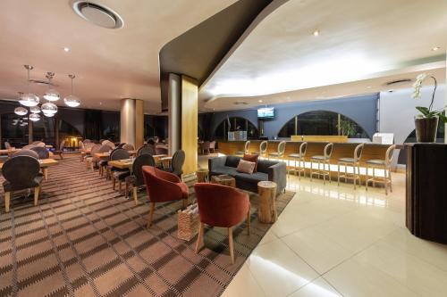 a restaurant with chairs and tables and a bar at Holiday Inn Express Cape Town City Centre by IHG in Cape Town