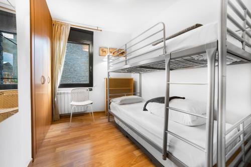 a bedroom with two bunk beds and a chair at La Devesa in Incles