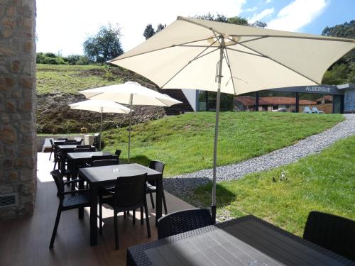 a group of tables and chairs with an umbrella at Hotel Casa Sueño in Salas