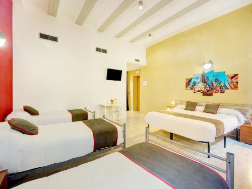 a room with two beds and a television in it at Casa Del Cigroner in Xàtiva