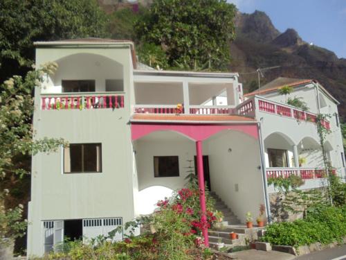 ein weißes Haus mit einem rosa Balkon in der Unterkunft Damontanha 2 in Ribeira Grande