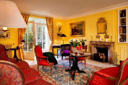 a living room with yellow walls and a fireplace at Le Clos de Villeroy in Mennecy