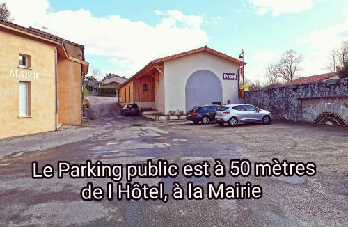 a building with two cars parked in a parking lot at Logis Hotel Restaurant LA BARGUILLERE in Saint-Pierre-de-Rivière