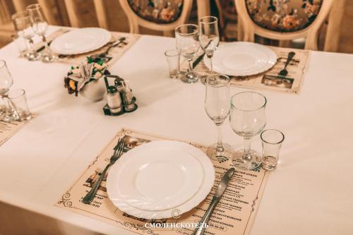 
a table topped with glasses and plates of food at Smolenskhotel in Smolensk
