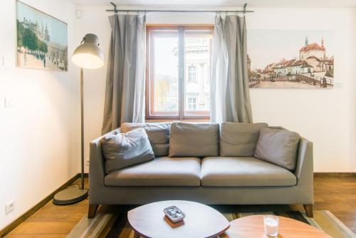 a living room with a couch and a window at Modern Apartment in a Picturesque 15th-Century Building in Prague