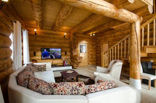 a living room with a white couch in a log cabin at Luxus-Ferienhaus Blockhaus Chalet Nr 1 Toplage am Feldberg mit Sauna, Outdoor-Hottub, Kamin auf 1300m üM in Feldberg