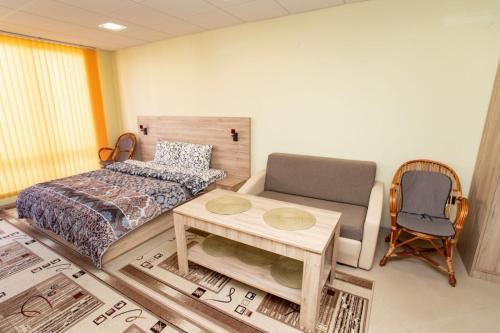 a bedroom with a bed and a table and a chair at Стая за гости Пентагона in Kŭrdzhali