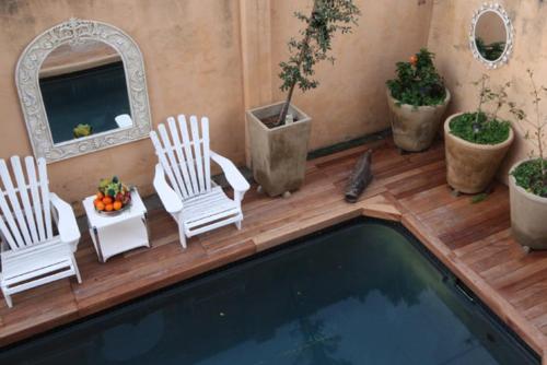 a patio with two chairs and a swimming pool at The Nantucket in Hermanus
