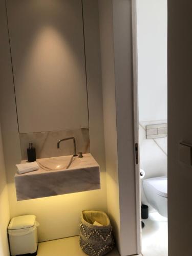 a bathroom with a sink and a toilet at Architectural poetry in an unique 3bdrs view flat in Lisbon