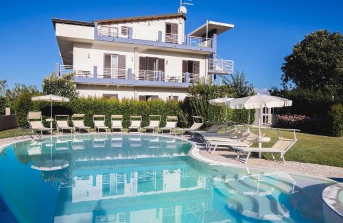a villa with a swimming pool in front of a building at Selenite in Capo dʼOrlando